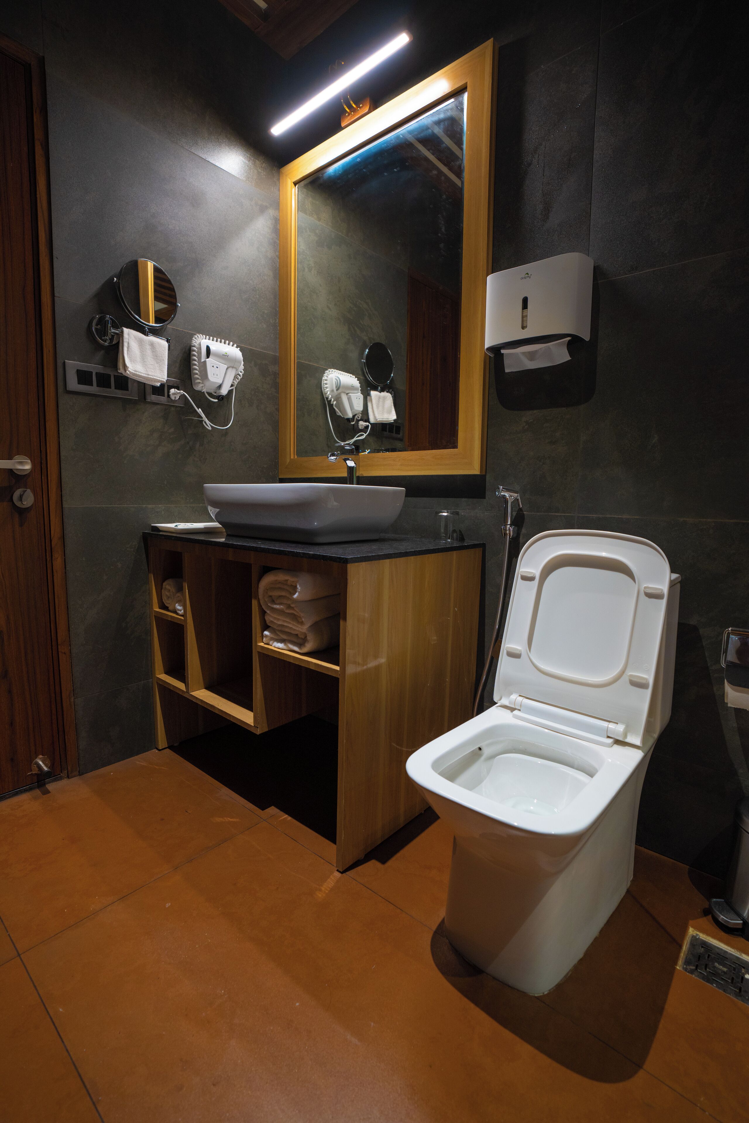 A modern bathroom with a white toilet, a sink, and a mirror.