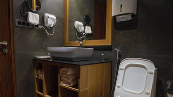 A modern bathroom with a white toilet, a sink, and a mirror.