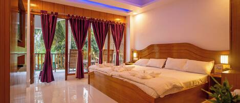 A spacious bedroom with a large bed, wooden headboard, and a ceiling fan.