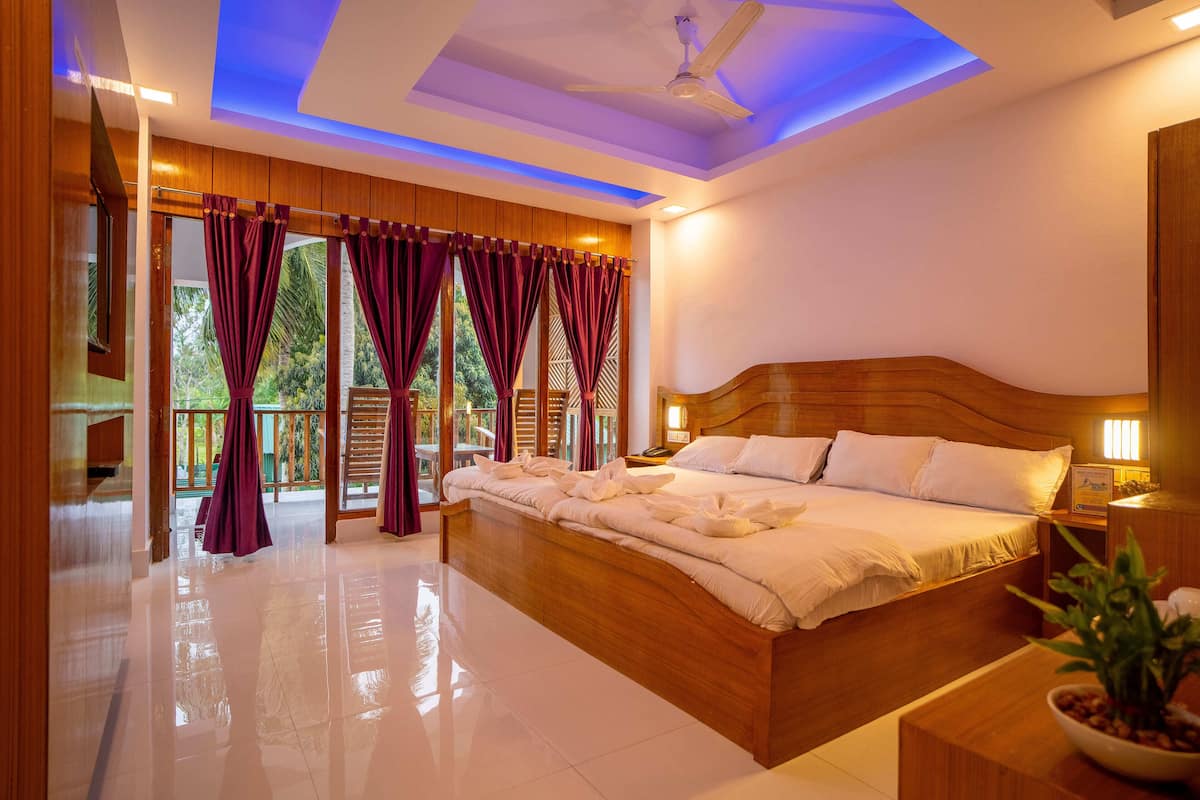 A spacious bedroom with a large bed, wooden headboard, and a ceiling fan.