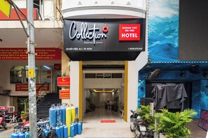 The exterior of the Madam CUC Bui Vien Hotel with a signboard, entrance, and surrounding area including parked motorcycles and gas cylinders. - Collection O Madam Cuc Bui Vien Hotel (Ho Chi Minh City)