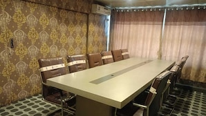 A conference room with a long table, six chairs, patterned wallpaper, and a tiled floor. - Vibor Hotel  (Kathmandu)