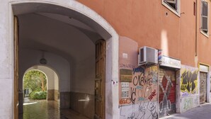 Een gewelfde doorgang die uitkomt op een betegelde gang met graffiti op de muren.