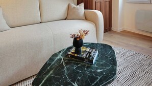 A modern living room with a sofa, a marble coffee table, wooden wardrobe, and artwork on the wall. - Elegant Apartment - 1br/4p - Sacre-coeur (Paris)