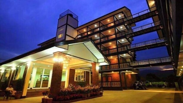 Un hotel de varios pisos con entrada cubierta y zona de estar al aire libre.