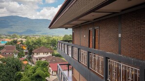 Un balcón con vistas a una zona residencial y montañas.