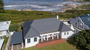 A coastal house with a large patio and ocean view.