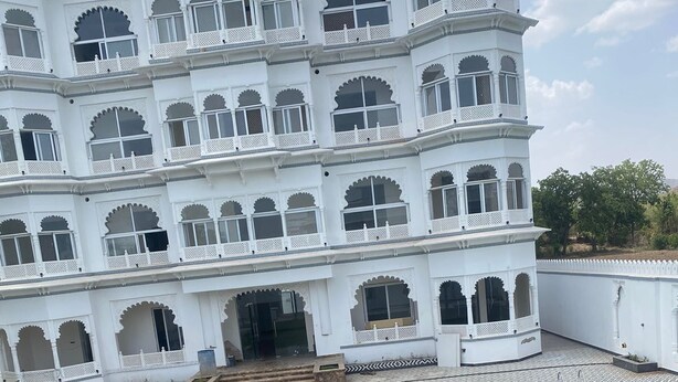 Un edificio grande y blanco con varios balcones y una piscina.