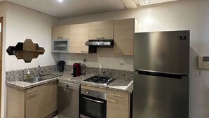 Uma cozinha moderna com eletrodomésticos de aço inoxidável, bancadas de granito e armários de madeira clara.