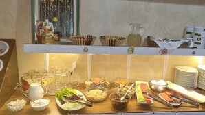 A buffet setup with various food items, utensils, and condiments. - The Sindh House Tbilisi (Tbilisi)
