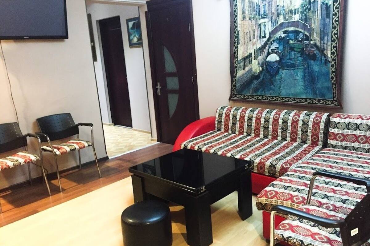 Una sala de estar con un sofá, una mesa de centro y un televisor.
