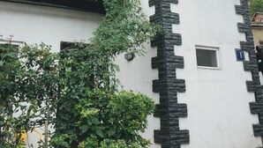A building with a stone facade, a balcony with metal railings, and a small window. - The Sindh House Tbilisi (Tbilisi)