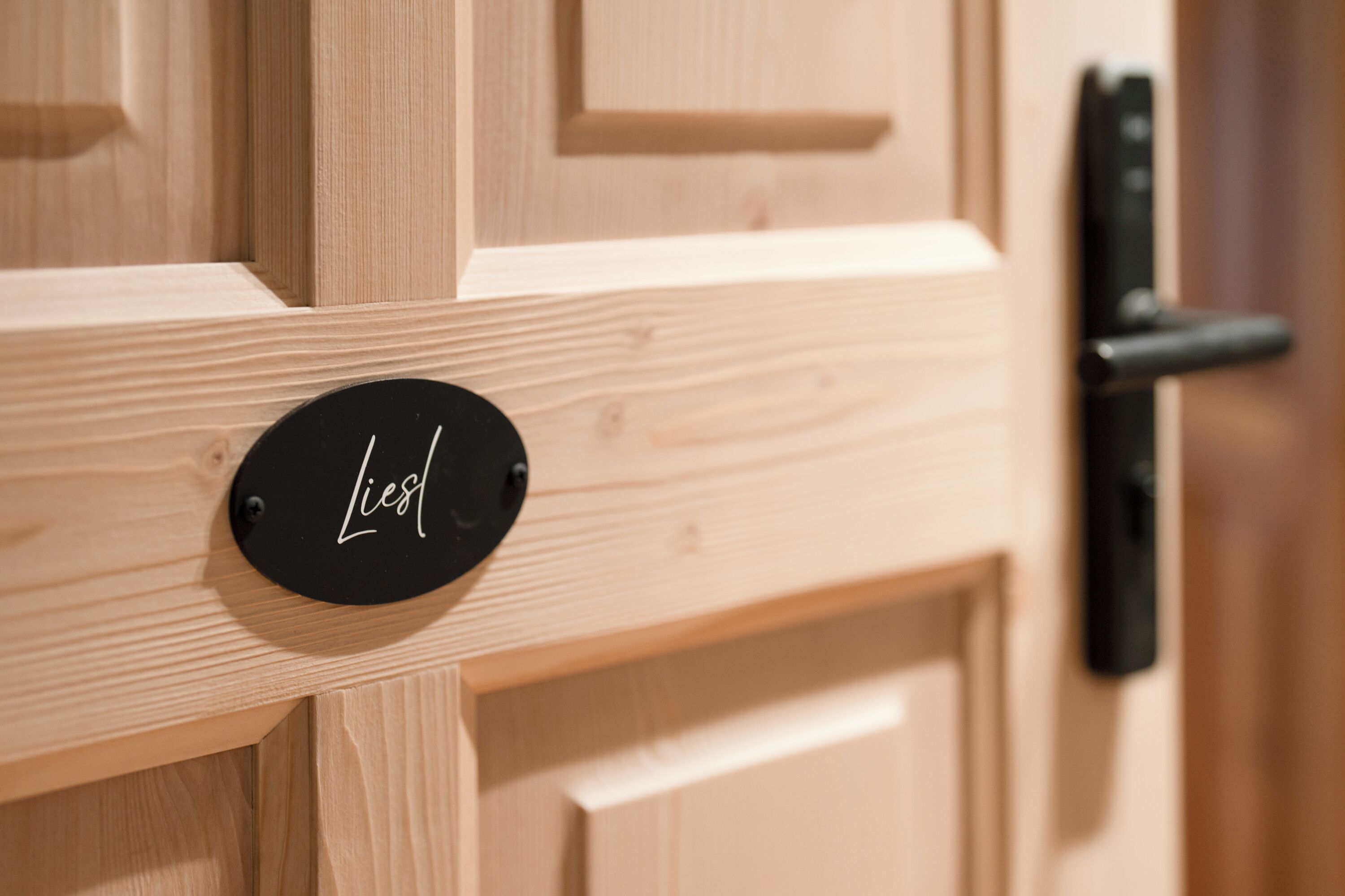 A wooden door with a black circular sign that reads "Liesl".
