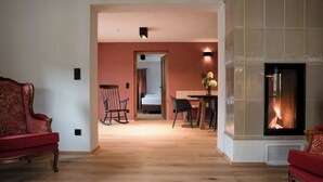 Un amplio salón con chimenea, un comedor y una habitación visible a través de una puerta abierta.