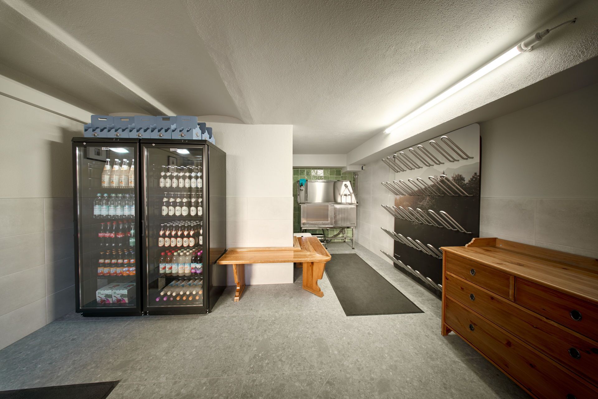 A modern kitchen with a built-in refrigerator, a wooden bench, and a wooden dresser.