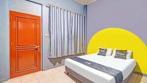 A bedroom with a bed, curtains, and a door. - Collection O Tanah Abang Near Stasiun Tanah Abang  Formerly Hotel Bimo Slipi (Jakarta)