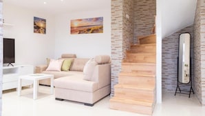 A modern living room with a sofa, coffee table, and artwork on the walls. - Apartments Milok (Piran)