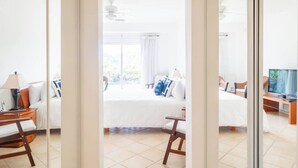 Ein Hotelzimmer mit Bett, Schreibtisch, Stuhl, Fernseher und Blick ins Freie.
