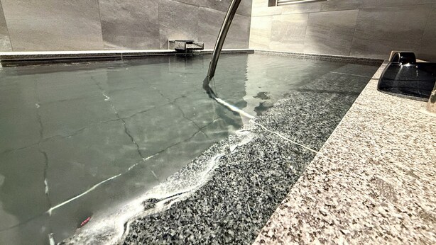 Un bassin de spa doté de jets d’eau, d’un banc et d’un système de ventilation mural.