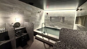 Une salle de bain moderne avec une baignoire sur pieds, un miroir rond et un comptoir en granit.