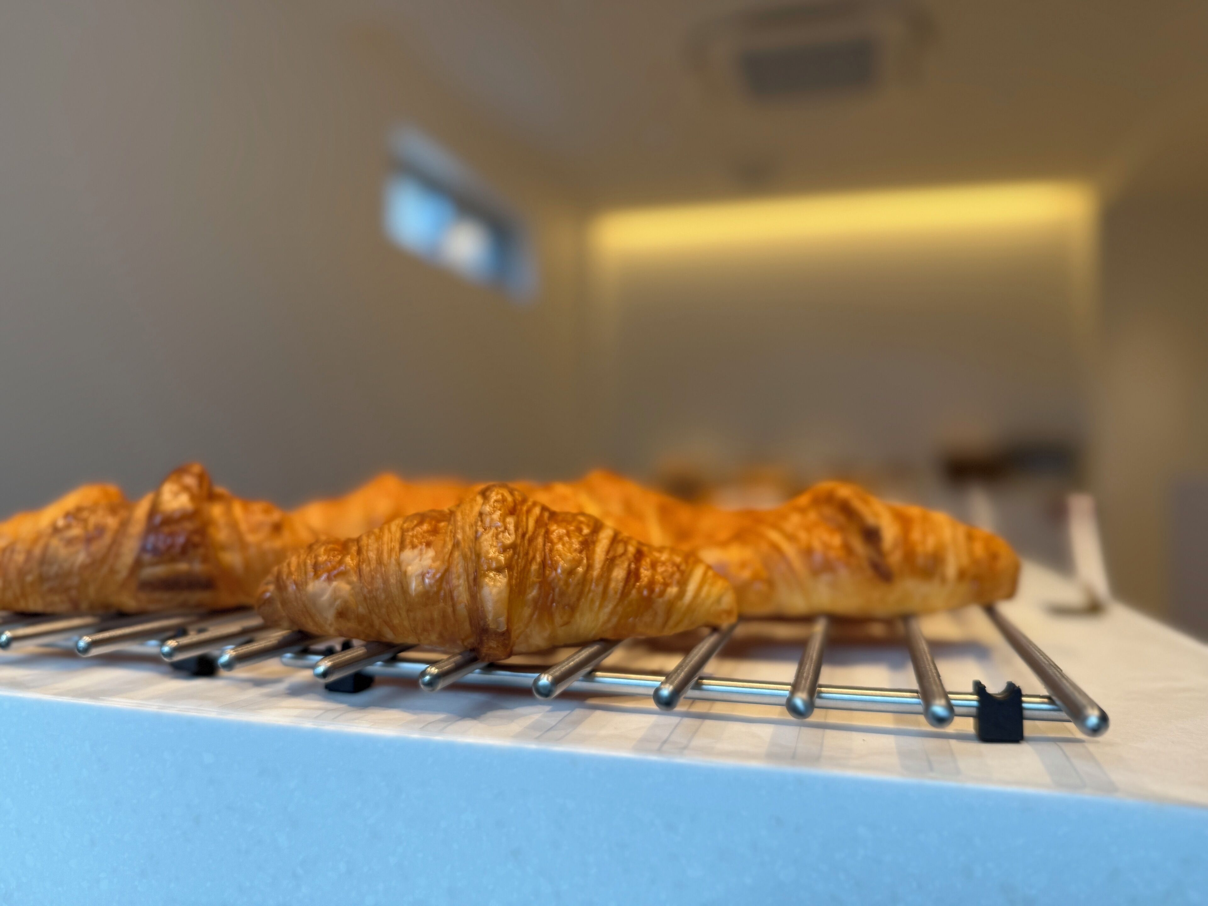 En croissant på ett metallställ i ett kök.
