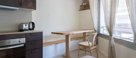 Eine kleine Küche mit Toaster, Kaffeemaschine und einem Holztisch.