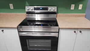 A kitchen with a stainless steel oven and a digital control panel.