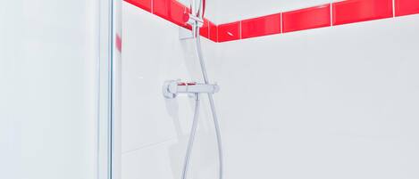 A shower with a handheld showerhead and a handheld hose.