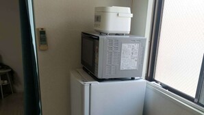 A compact kitchen with a refrigerator and microwave. - Shin Awaji Building II 202  (Osaka)