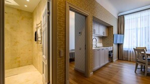 A modern apartment with a kitchen, dining area, and a bathroom with a shower. - Roze Kūrmājas Residence (Liepaja)