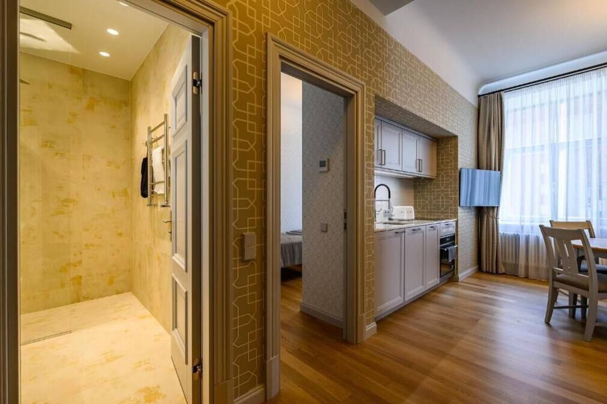 Un apartamento moderno con cocina, comedor y baño con ducha.