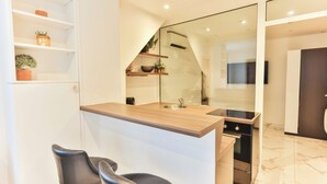 Een moderne keuken met een houten aanrecht, zwarte stoelen en een inbouwoven.