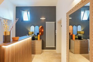 Un baño moderno con tocador de madera, espejo, radiador y ventana.