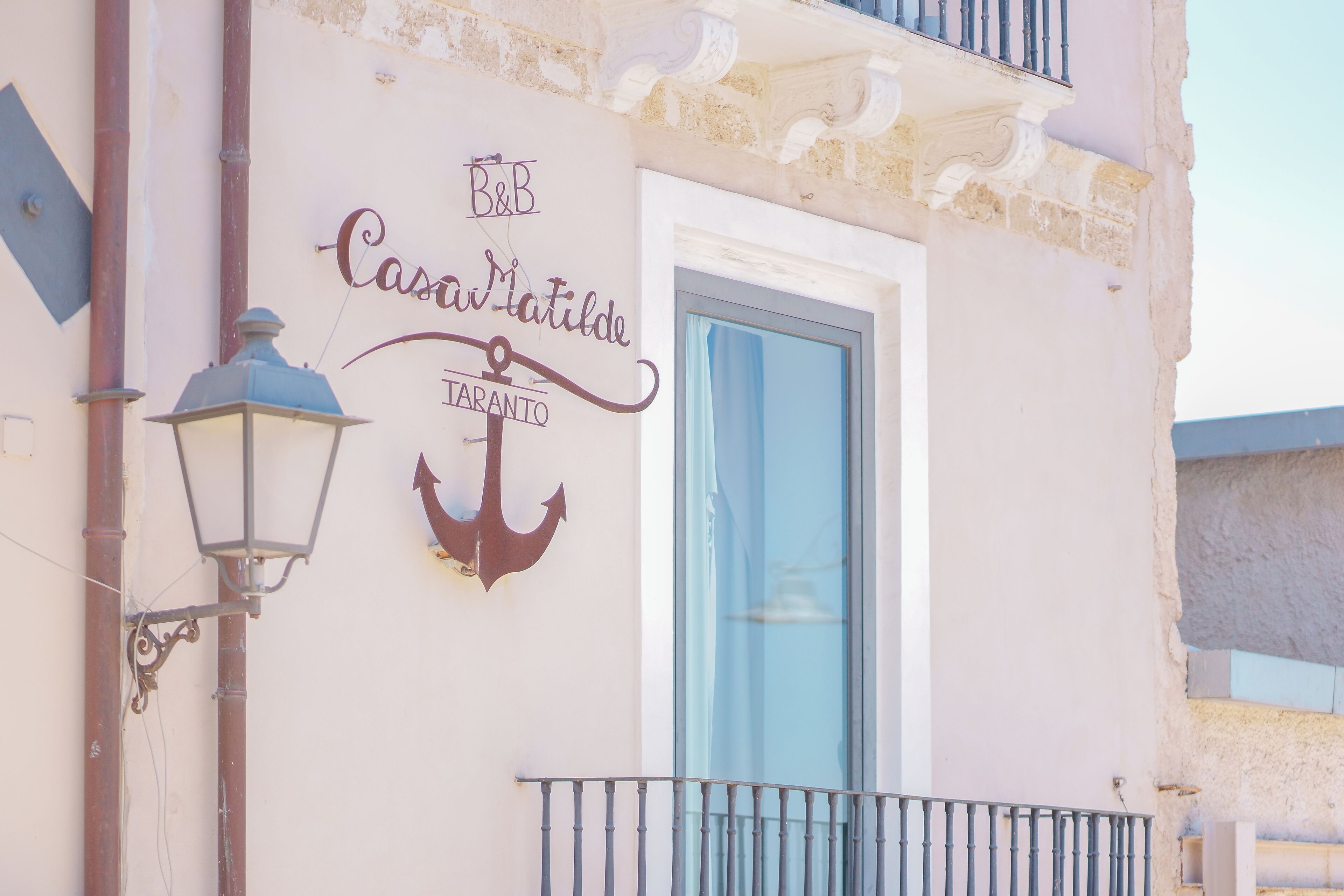 Ein Gebäude mit einem Schild, auf dem "B&B Casa Matilde TARANTO" steht, und einem Ankersymbol.