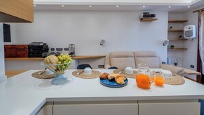 Een moderne keuken met een ontbijttafel, compleet met fruit, gebak en sinaasappelsap.