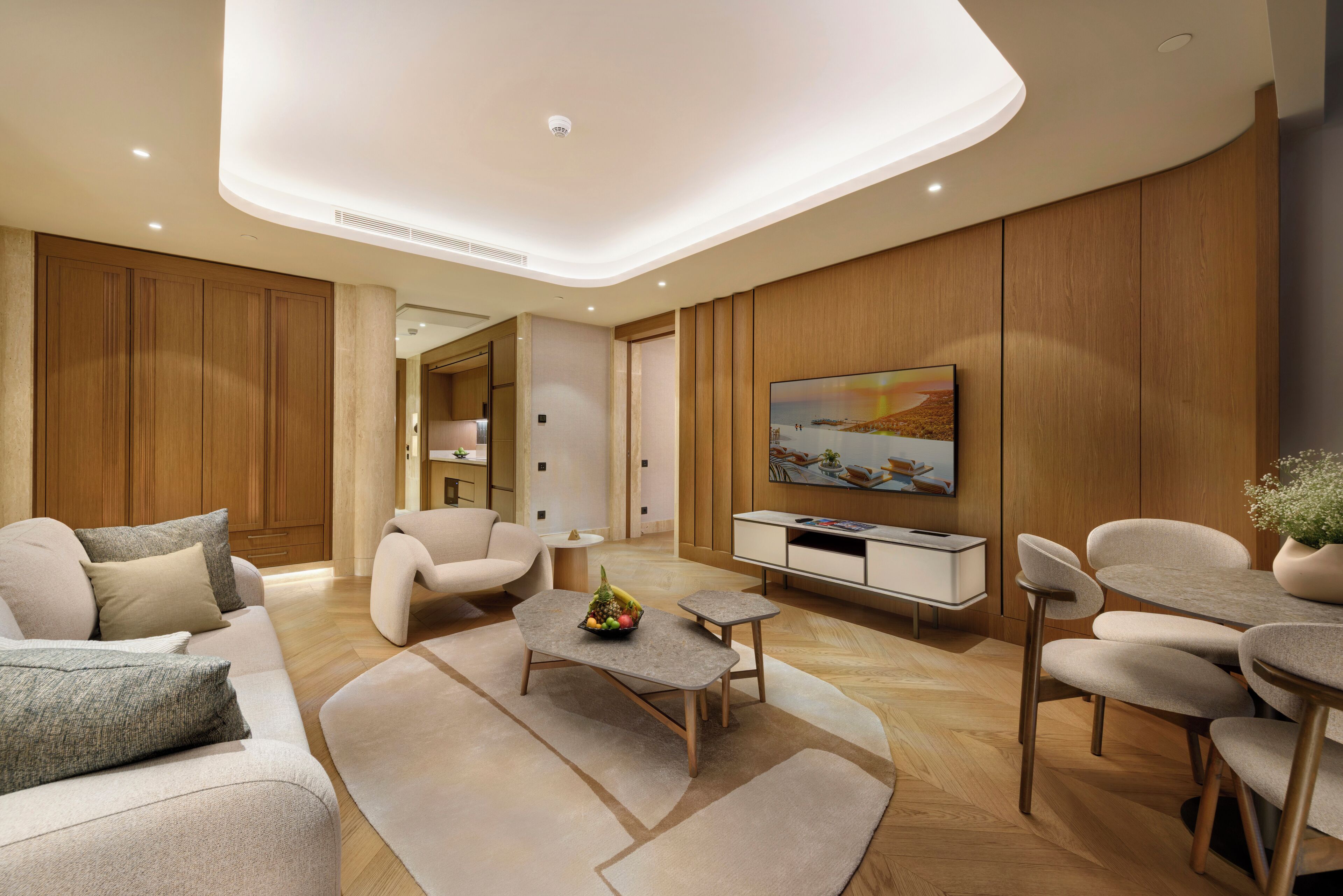 A modern living room with a sofa, coffee table, TV, and wooden paneling.