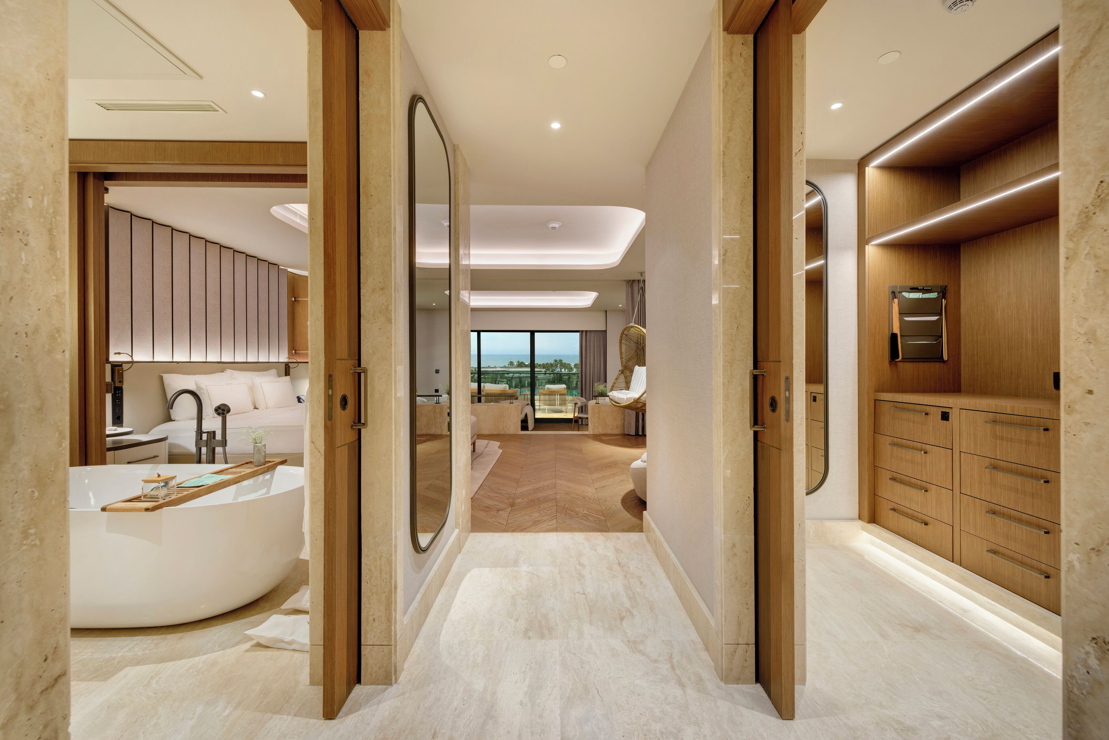 Une salle de bain moderne avec une baignoire sur pieds, des meubles en bois et une vue sur l’espace de vie.