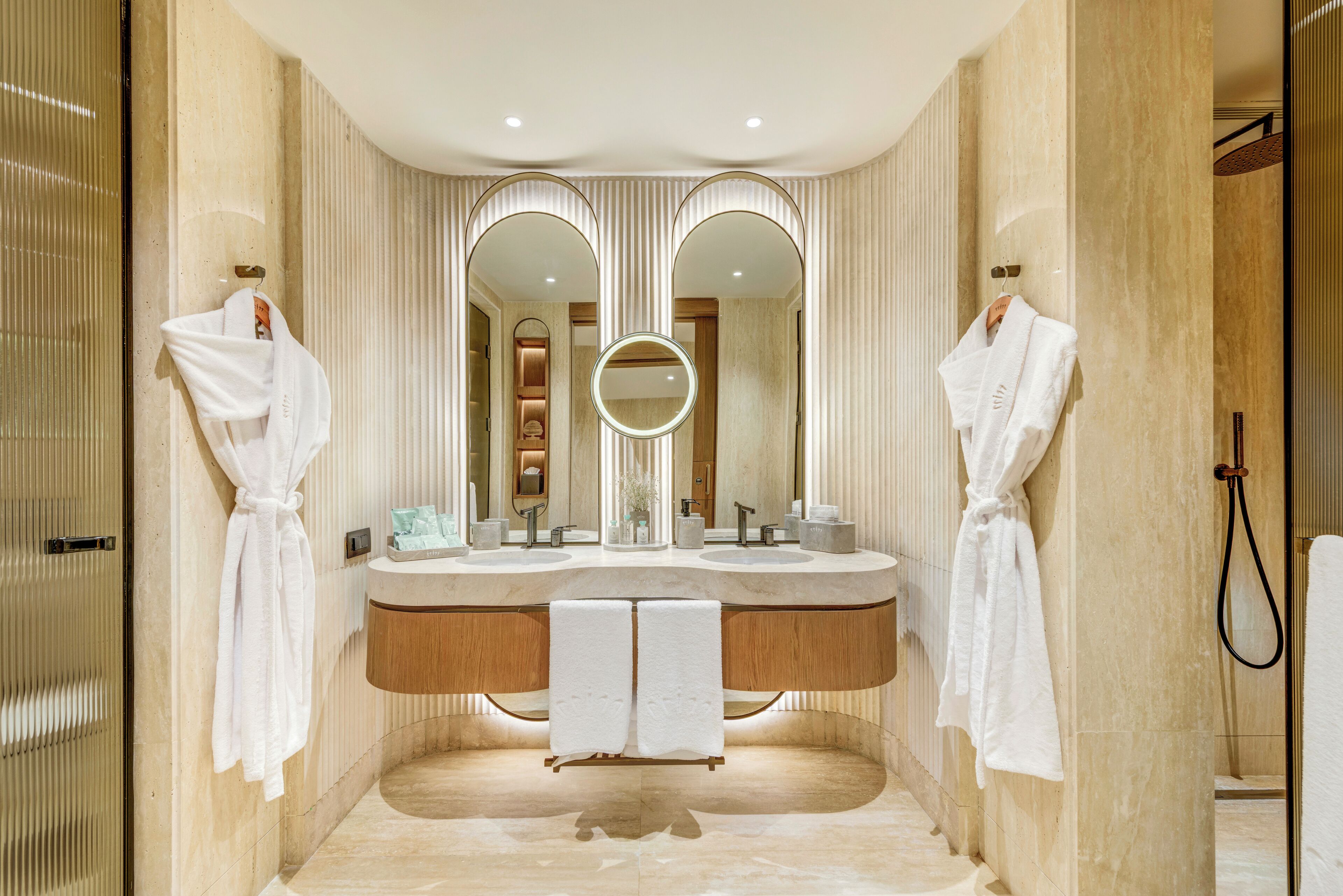 Un baño moderno con lavamanos doble, dos espejos grandes y cabina de ducha.