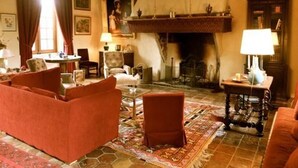 A cozy living room with a fireplace, comfortable seating, and a rug. - Historic cottage in charming castle near Le Mans (Saint-Pavace)