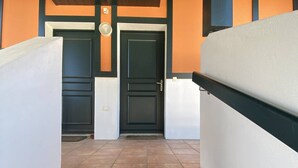 A staircase leading to a set of double doors with a light fixture above them.