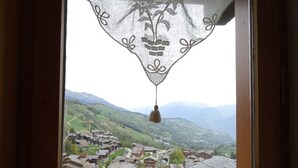 Une vue sur un village avec des maisons traditionnelles et une chaîne de montagnes en arrière-plan.