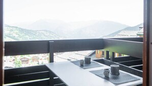 Un balcon offrant une vue sur des montagnes lointaines et une ville.