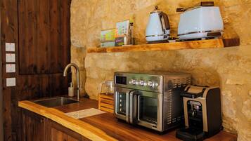 A kitchen with a built-in oven, a coffee maker, and a toaster on a wooden countertop.