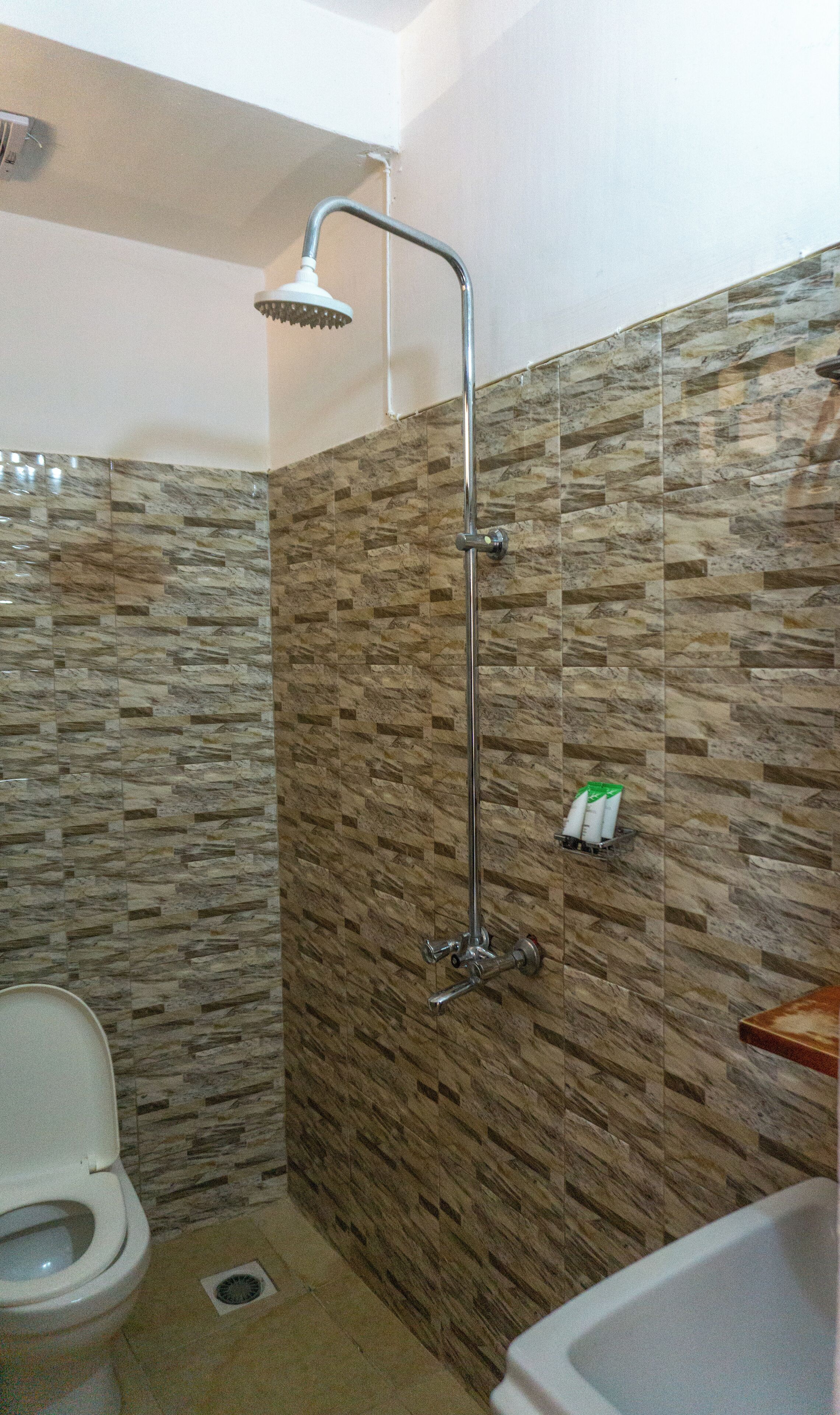 Une salle de bain avec une douche, des toilettes et un lavabo.