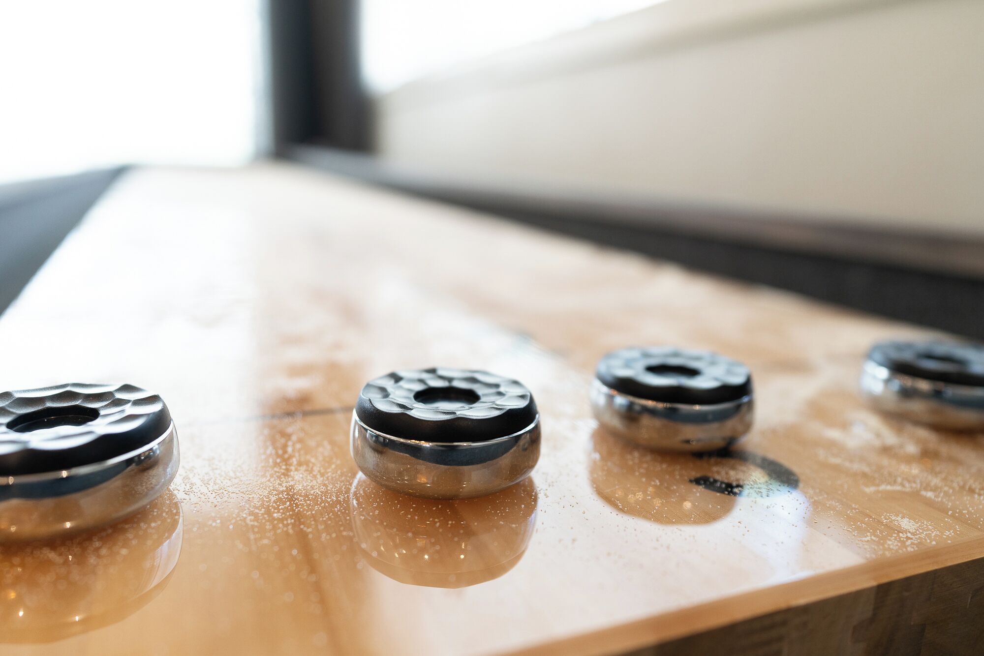 Primer plano de una superficie de madera con varios objetos metálicos, posiblemente rodamientos.