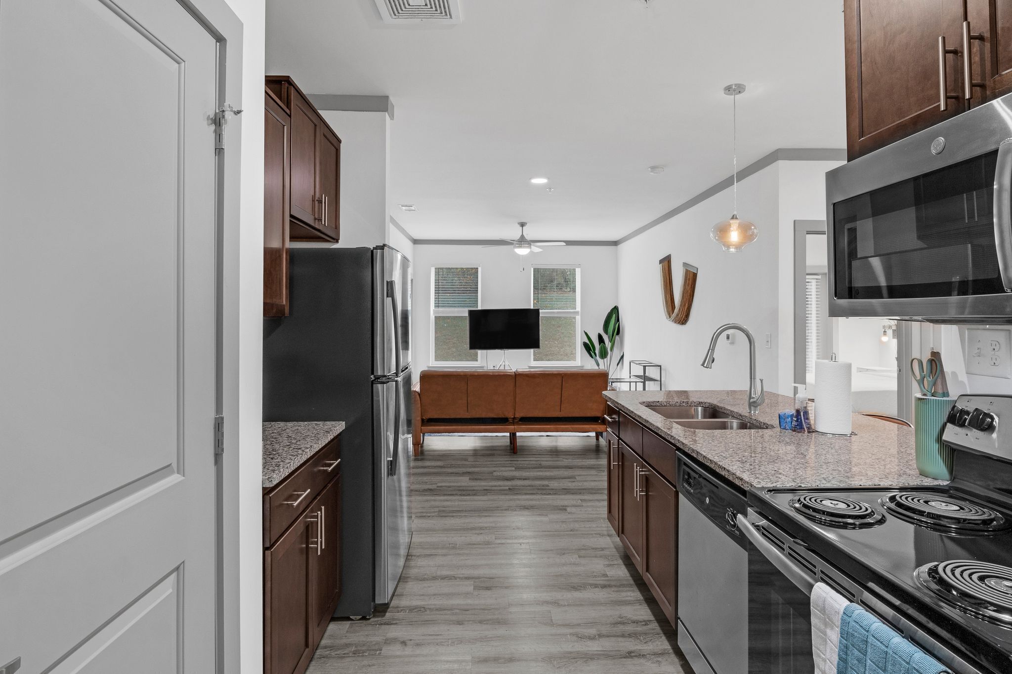 Una cocina moderna con una isla central, electrodomésticos de acero inoxidable y armarios de madera.