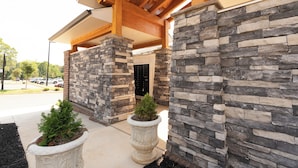 A building entrance with stone walls and a covered porch area.