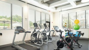 A gym with treadmills, elliptical machines, and a stationary bike.
