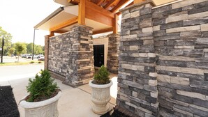 A building entrance with stone walls and a covered porch area.