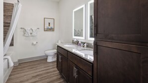 A bathroom with a shower, toilet, double sink vanity, and a large mirror. - Overlook 4302 I Stunning 2Bd/2Bth Apt I Pool (Knoxville)